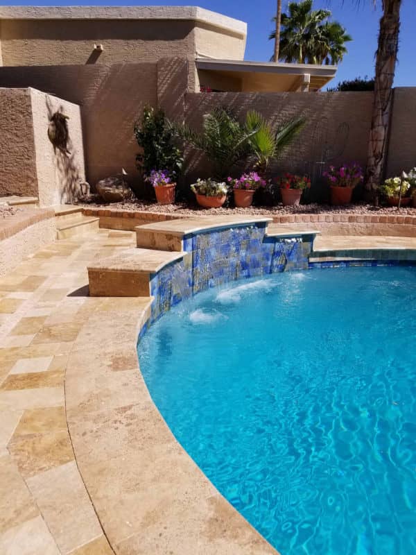 After: The new plaster surface, tile deck and water feature make the pool look like new!