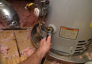 There is a garden hose-type connection at the base of the water heater. Attach a hose to the tank and place the other end of the hose outside.