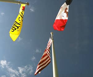 American, Dutch and Pella flag flying in from of Pella Windows & Doors headquarters in Pella, Iowa. 