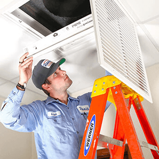 Man changing out a home air filter at the air return register/vent